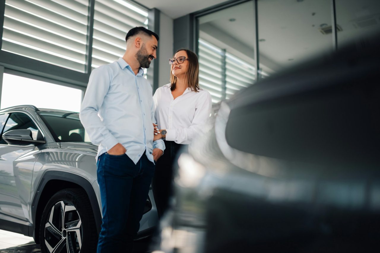 couple-contemplating-car-purchase-in-bright-dealership-showroom.jpg